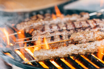 Lambs kebab on a ceramic barbecue with fire. Cast iron grill. Close-up. Skewer. High quality photo