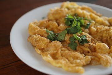 Side view of Omelet top with coriander on wood table.(Thai style)