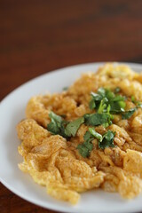 Angle view of Omelet top with coriander on wood table.(Thai style)