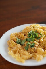 Angle top view of Omelet and top with coriander on wood table.(Thai style)
