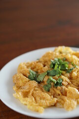 Angle top view of Omelet and top with coriander on wood table.(Thai style)