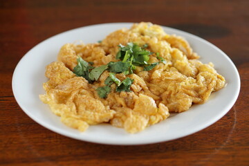 Side view of Omelet and top with coriander on wood table.(Thai style)