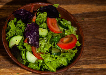 vegetarian diet salad in a plate on an oak table top view
