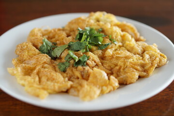 Close up of Omelet and top with coriander on wood table.(Thai style)