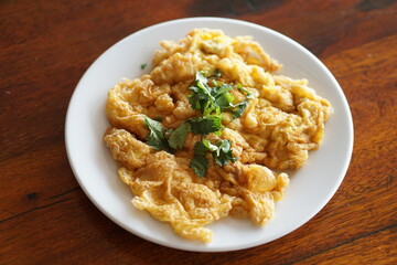 Angle top view of Omelet and top with coriander on wood table.(Thai style)