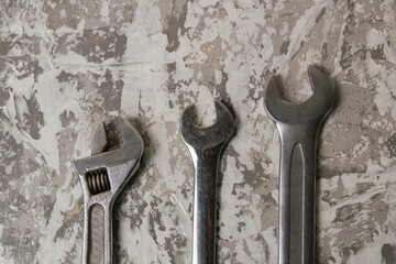 Old wrenches on a background of gray artistic putty with a place to insert text