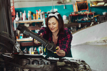 Fototapeta na wymiar Girl repairing a car in the garage