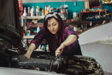 Obraz na płótnie Canvas Girl repairing a car in the garage