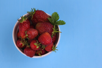 juicy ripe strawberries on a blue background, top view, copy space, banner.