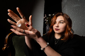 Woman in black suit holding crystal ball