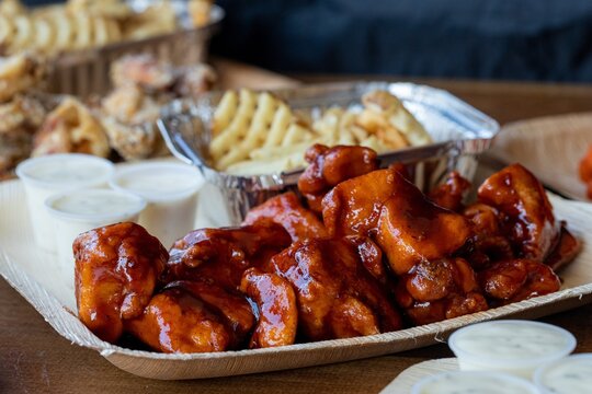 Closeup Shot Of Roasted Beef Dipped In Barbeque Sauce In A Paper Container