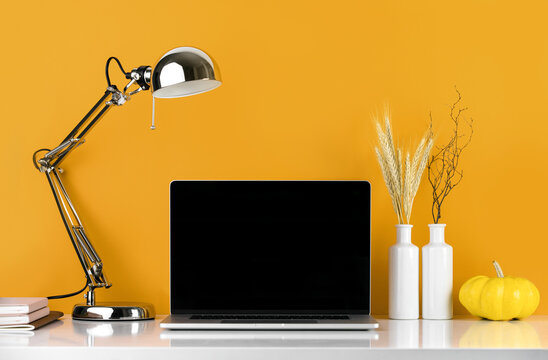 Fall decorated working space with a laptop on the desk, social media concept