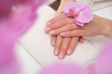 Female hands in spa. Close up to pretty done manicure. Orchid mood.