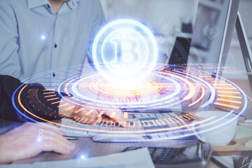 Crypto currency theme hologram with businessman working on computer on background. Concept of...