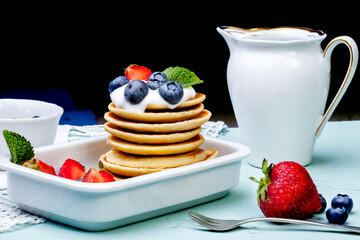 Pancakes with fresh blueberries, strawberries and cream cheese. Fresh blueberries and mint. Breakfast