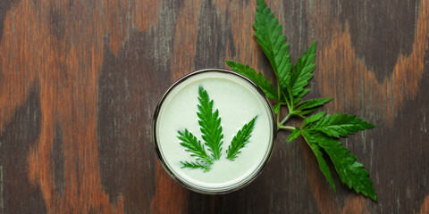 Obraz na płótnie Canvas Cannabis herbal vegan gluten free lactose free milk and cannabis leaves. Top view