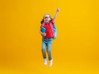 Kid with backpack on color background.