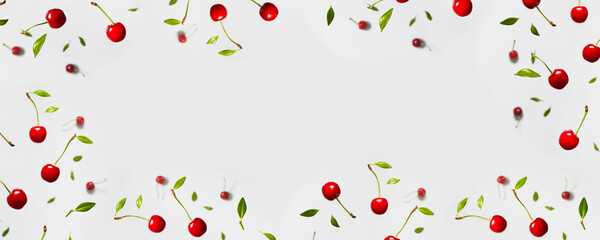 Ripe cherry berry with green leaves levitating on white background. Berry summer background. Flat lay, top view, copy space