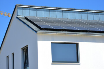 Neue Solaranlage auf dem schwarzen Ziegeldach eines moderen Einfamilien-Neubauhauses