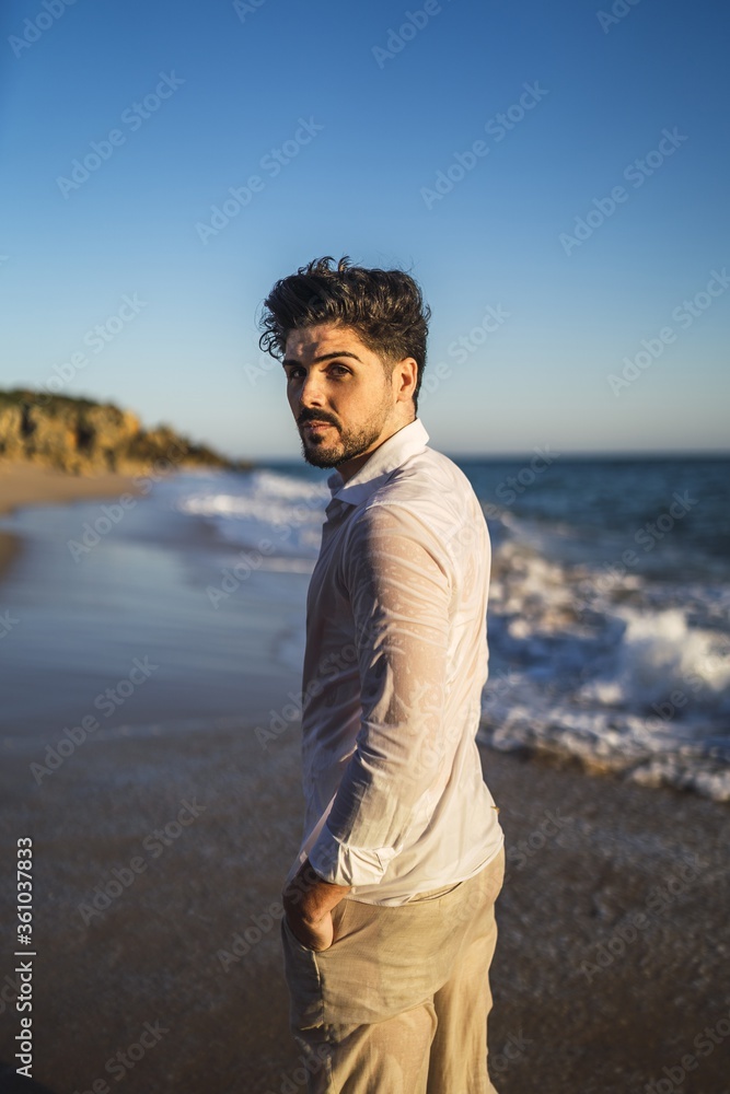 Canvas Prints Vertical picture of a brunette male against a wavy ocean