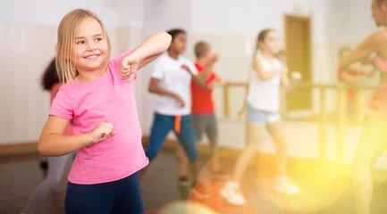 Gordijnen Girl exercising in group during dance class © JackF