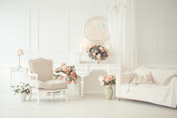 luxury clean bright white interior. a spacious room with sunlight and flowers in vases and royal chic furniture. 