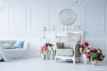 luxury clean bright white interior. a spacious room with sunlight and flowers in vases and royal chic furniture. 
