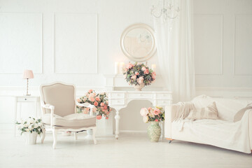 luxury clean bright white interior. a spacious room with sunlight and flowers in vases and royal...