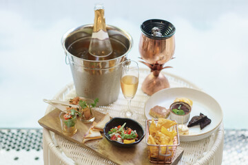 Glass of wine and wine bottle with different snacks and appetizers food at a cocktail party.