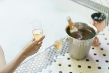 Woman Hand with glass of wine, near the bubble pool