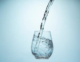 Water Pouring Into a Glass on a blue gradient