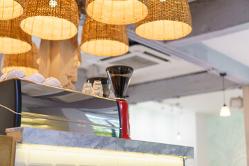 Coffee shop bar counter, coffee machine, cafe restaurant decoration by wicker basket lamp.