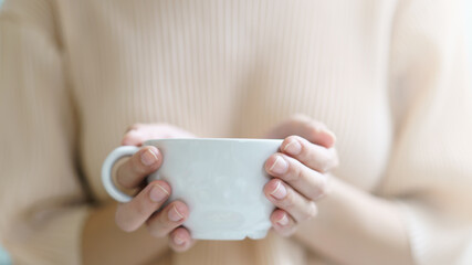 Cup of coffee. Woman drinking tea or coffee. White cup of hot beverage in the morning.