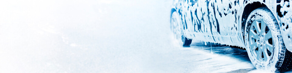 Car wash. Black car in active foam on a white background, banner.