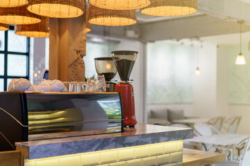 Coffee shop bar counter, coffee machine, cafe restaurant decoration by wicker basket lamp.