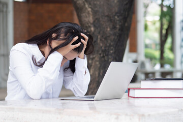 Tired Indian asian woman studying or working from home with computer; concept of problem in...