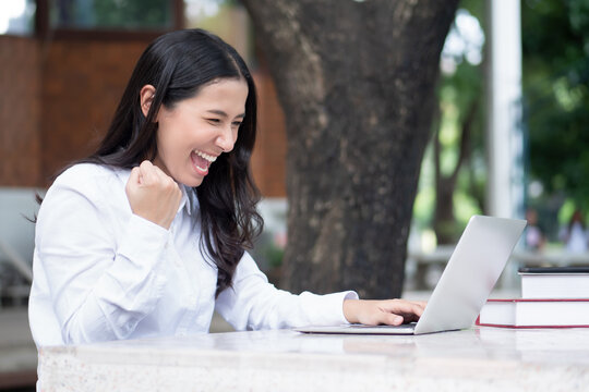 excited laughing Indian asian woman study from home with computer; concept of distance learning, online course, telelearning, internet work or study, social distancing, physical distancing, new normal