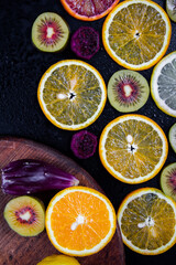 برخی از بخش های پرتقال ، پرتقال خون ، کیوی بر روی زمینه سیاه.