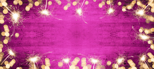 Frame of lights bokeh lights flares and sparkler isolated on pink painted wooden texture - Holiday...