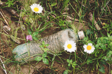 earth nature pollution with plastic waste and water bottles, spilled garbage on the grass