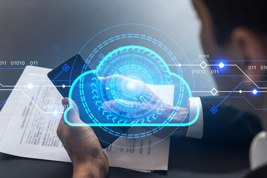 Businessman in office working with Smartphone, IT Cloud hologram to optimize the working process, typing phone. Double exposure.
