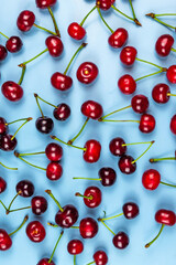 Obraz na płótnie Canvas Red juicy cherries on a blue