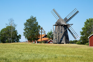 Fototapeta na wymiar Windmill and midsummer pole in Sweden