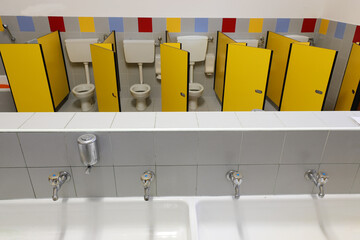 sink with  taps inside a kindergarten with toilets with yellow d