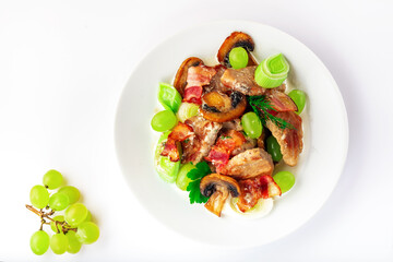 Pork with mushrooms, grapes, leek and parsley. High key. Selective focus.