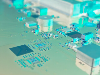 Fragment of a PC motherboard. Part of the main circuit board close-up. Bright aquamarine inverted background or wallpaper on the theme of electronic or computing equipment and computer hardware. Macro