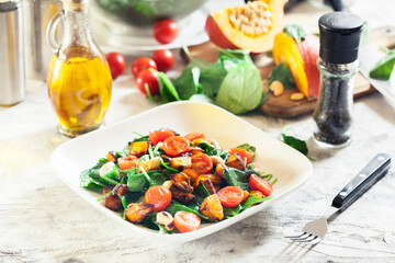Roasted pumpkin salad with spinach, tomatoes and nuts