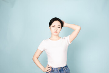 Fototapeta na wymiar A young chinese woman in front of blue background