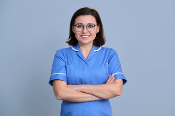Portrait of confident smiling female nurse with arms crossed looking at camera