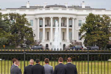Spring, 2016 - Washington DC, USA - Young people in business dark suits stand with their backs to...